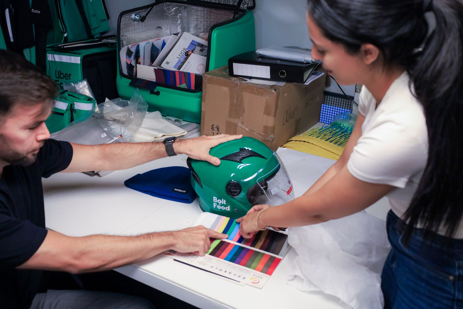 Boolanga team checking a Bolt Food helmet sample against colour swatches